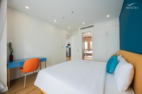 a bedroom with a white bed and a blue desk at Luna Sol Villas - Dedicated Care Until Check Out in Phu Quoc