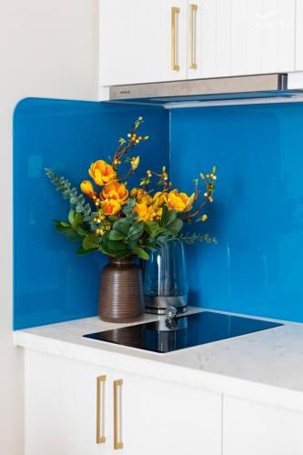 a vase with yellow flowers sitting on a kitchen counter at Luna Sol Villas - Dedicated Care Until Check Out in Phu Quoc