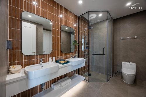 a bathroom with two sinks and a shower and a toilet at Luna Sol Villas - Dedicated Care Until Check Out in Phu Quoc