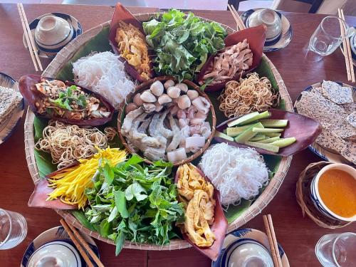 a table with two plates of food on it at GOLDEN LOTUS SPA & HOMESTAY in Ấp Thiện Phước