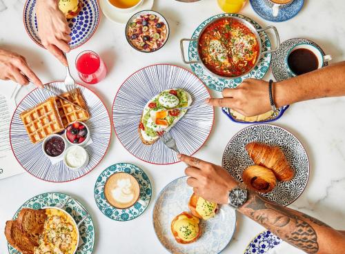a group of people sitting at a table eating breakfast at Hyatt Centric Jumeirah Dubai in Dubai