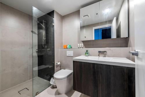 a bathroom with a toilet and a sink and a shower at High Society Apartment Belconnen in Belconnen