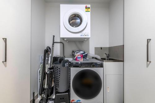 a kitchen with a washing machine and a dryer at High Society Apartment Belconnen in Belconnen