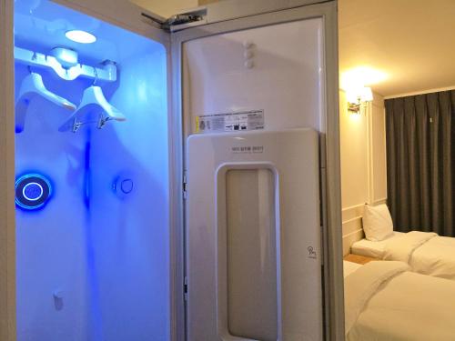 a room with a refrigerator in a room with a couch at JK Blossom Hotel in Seoul