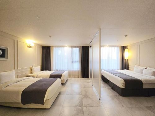 a hotel room with two beds and windows at JK Blossom Hotel in Seoul
