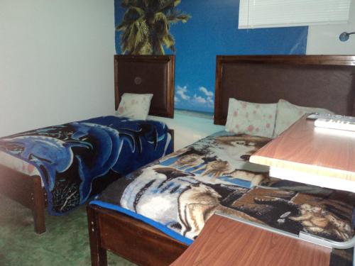 a bedroom with two beds and a desk and a table at Cabinas Dormi Bene in Miramar
