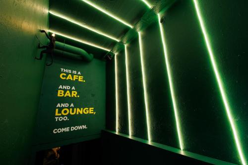 a sign that says a cafe and a bar and a loungetootoocome down at Little Monkey Hostel in Enschede