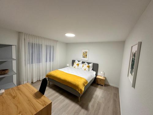 a bedroom with a bed with a yellow blanket at Dream-Stay I Zentral I cosy I Basel in Pratteln