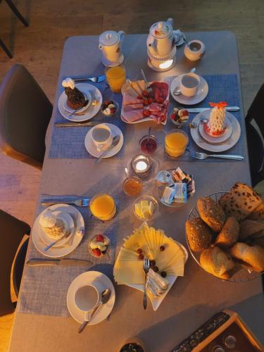 a table with breakfast foods and drinks on it at Hotel Garni Kastanjehoff in Timmel