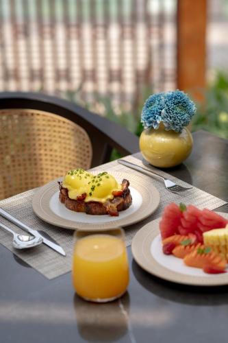 un tavolo con due piatti di cibo e un bicchiere di succo d'arancia di Regent Bali Canggu a Canggu
