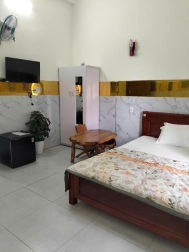 a bedroom with a bed and a table and a television at Tam Ky XO Hotel in Tam Ky