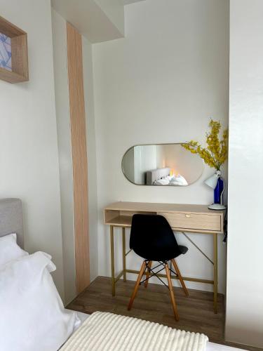 a bedroom with a desk with a mirror and a chair at Cozy Condo bedroom in Bacolod City in Bacolod