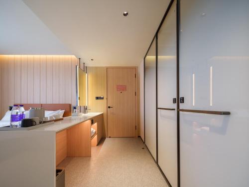 a kitchen with a counter and a refrigerator at 桔作酒店 郑州中州大道中原国际博览中心店 in Zhengzhou
