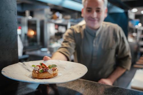 a man holding a plate of food on a counter at Serras Barcelona in Barcelona