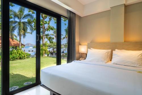 a bedroom with a bed and a large window at Bintang Flores Hotel in Labuan Bajo