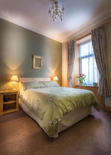 a bedroom with a large bed and a window at Lakeview Guest House in Stranraer