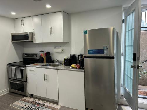 a kitchen with white cabinets and a stainless steel refrigerator at Dream Homes in Thorold