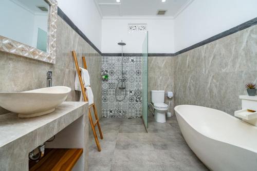 a bathroom with a tub and a sink and a shower at Villa Made Ubud in Ubud