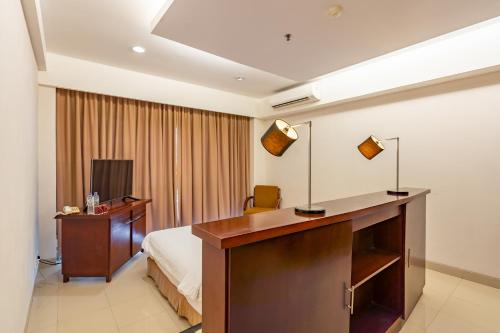a hotel room with a bed and a desk and a desk at Bintang Flores Hotel in Labuan Bajo