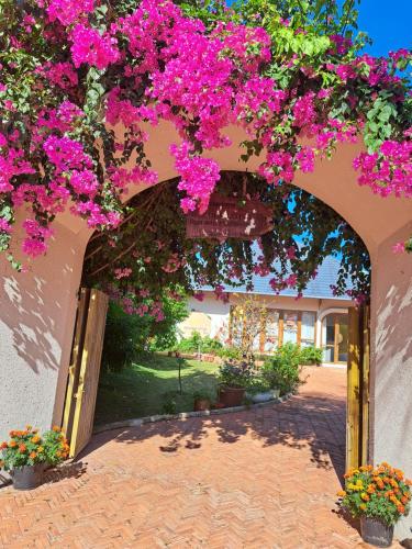 an archway with bougainvillea plants and flowers at GOLDEN LOTUS SPA & HOMESTAY in Ấp Thiện Phước