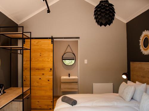 a bedroom with a bed and a mirror at Stay At Simbali in Tierpoort