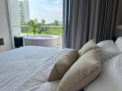 a bedroom with a bed with a view of a tub at Suite Top Frente al Mar en el Hotel Portohorizonte in Santa Marta
