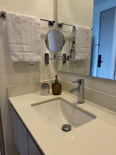 a bathroom with a sink with a mirror and towels at Suite Top Frente al Mar en el Hotel Portohorizonte in Santa Marta