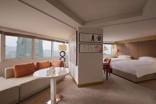 a hotel room with a bed and a couch and a table at Grand Hyatt Taipei in Taipei