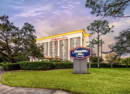 a sign in the grass in front of a hotel at Hampton Inn Orlando-International Airport in Orlando