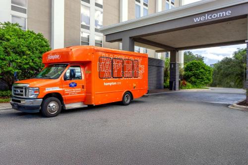 an orange truck parked in front of a building at Hampton Inn Orlando-International Airport in Orlando