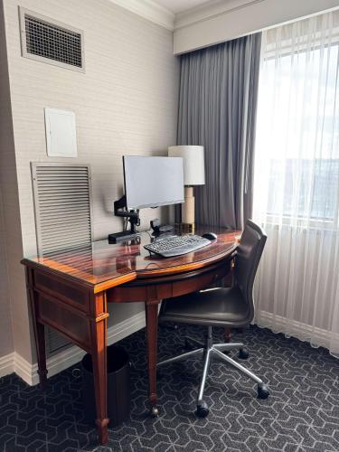 a desk with a computer and a chair in a room at Hilton Short Hills in Short Hills