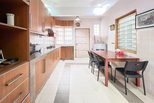 a kitchen with a wooden table and black chairs at Homestay Taman U12, Shah Alam - Smarthome in Shah Alam