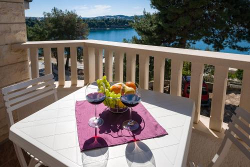 een tafel met twee wijnglazen en een fruitschaal bij Apartments Villa Luxor in Trogir