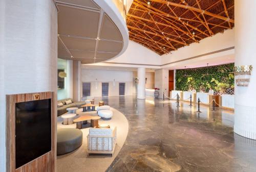 a lobby with couches and tables in a building at Centara Grand Mirage Beach Resort Pattaya in North Pattaya