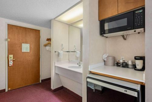 a bathroom with a sink and a microwave at AmericInn by Wyndham Denver Airport in Denver