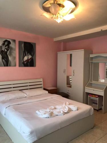 a bedroom with a bed with two white towels on it at You Place in Pattaya