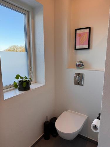 a bathroom with a toilet and a window at Panoramic Holiday Apartment - Dagmar in Ebeltoft