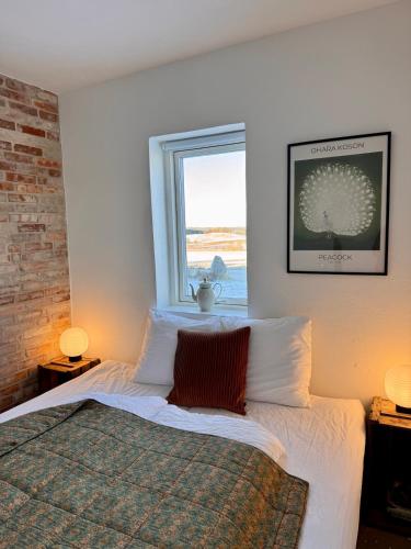 a bedroom with a bed with white sheets and a window at Panoramic Holiday Apartment - Dagmar in Ebeltoft