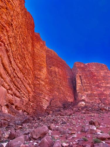 a red canyon with rocks and a blue sky at Wadi Rum Wild Camp Desert in Wadi Rum