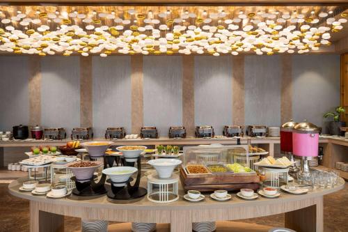 a buffet of food on a table in a restaurant at Wyndham Garden Sonipat Murthal in Sonīpat