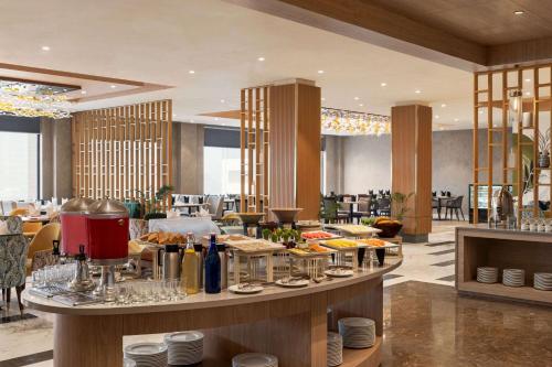 a restaurant with a buffet line with food on display at Wyndham Garden Sonipat Murthal in Sonīpat