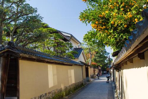 a street with an orange tree next to a building at Tokyu Stay Kanazawa in Kanazawa
