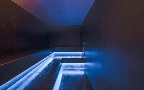 a bath tub with blue lights in a room at Hotel Plan de Gralba - das Berghotel in Selva di Val Gardena