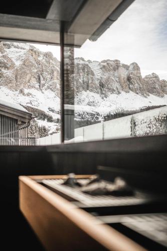 a window with a view of a snowy mountain at Hotel Plan de Gralba - das Berghotel in Selva di Val Gardena