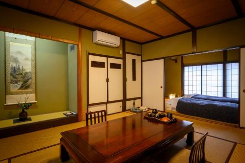 a living room with a table and a bed at 岩井温泉　岩井屋 in Iwamicho