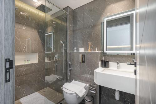 a bathroom with a toilet and a sink and a shower at Free housekeeping visits during your stay - StayShort - Delightful Studio in Park Views that Sleeps 2 in Dubai