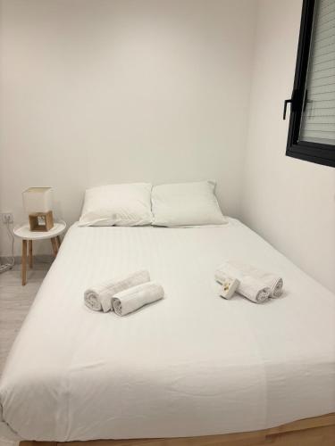 - un lit blanc avec 3 serviettes dans l'établissement Élégant T2 à 100m de la plage - Proche Aéroport, à Cagnes-sur-Mer