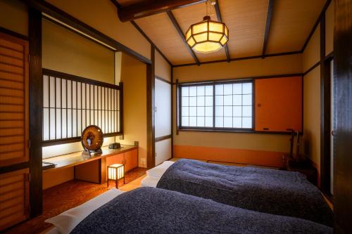 two beds in a room with two windows at 岩井温泉　岩井屋 in Iwamicho