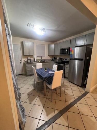 a kitchen with a table and chairs and a refrigerator at Simplicity Stays NOLA 2 in New Orleans
