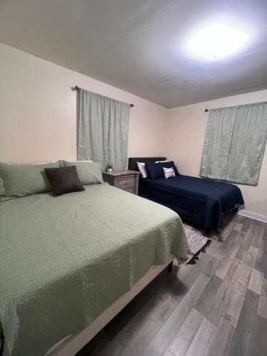 a bedroom with two beds and a window with curtains at Simplicity Stays NOLA 2 in New Orleans